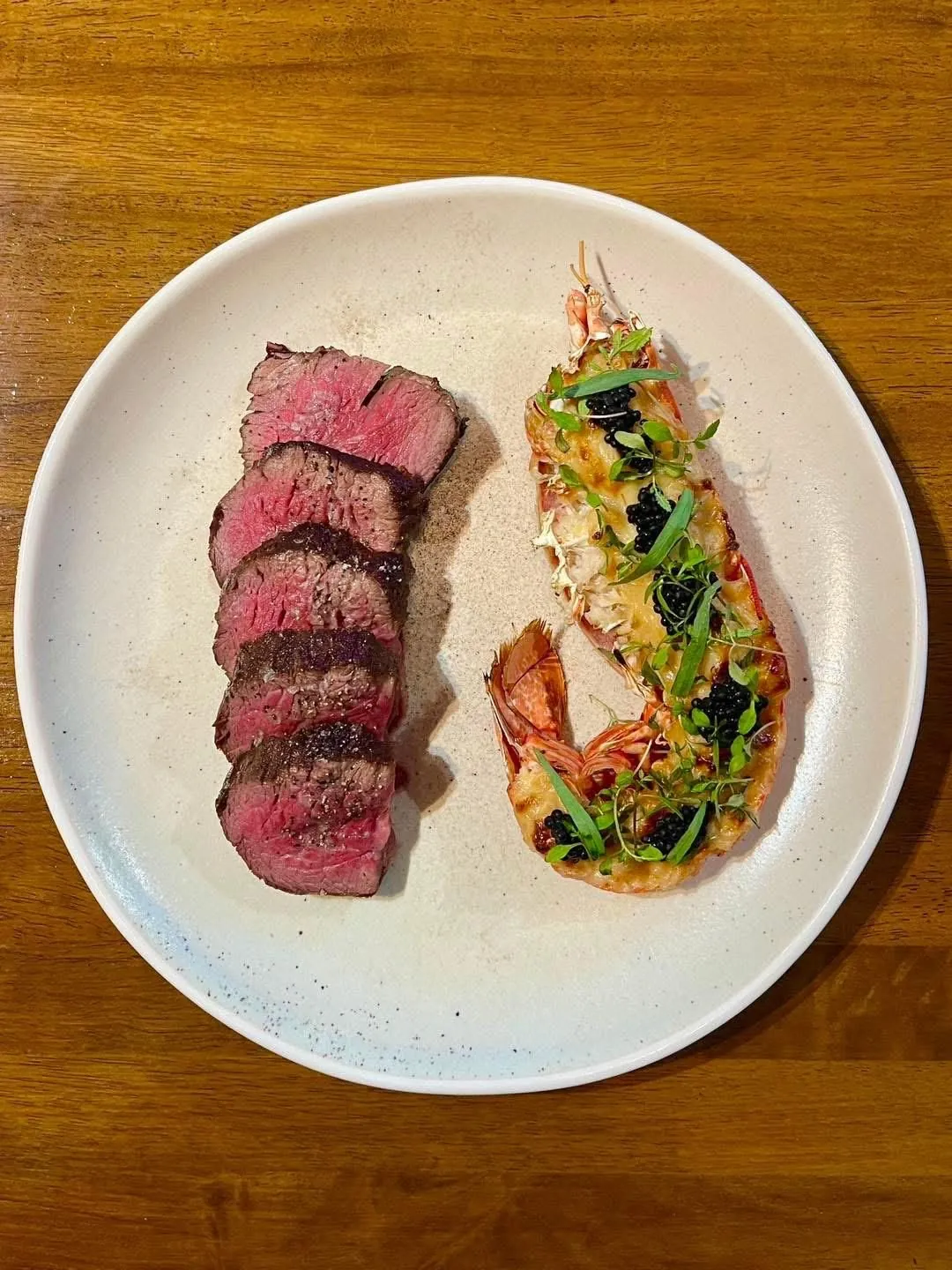 Sliced rare meat beside a dressed salad
