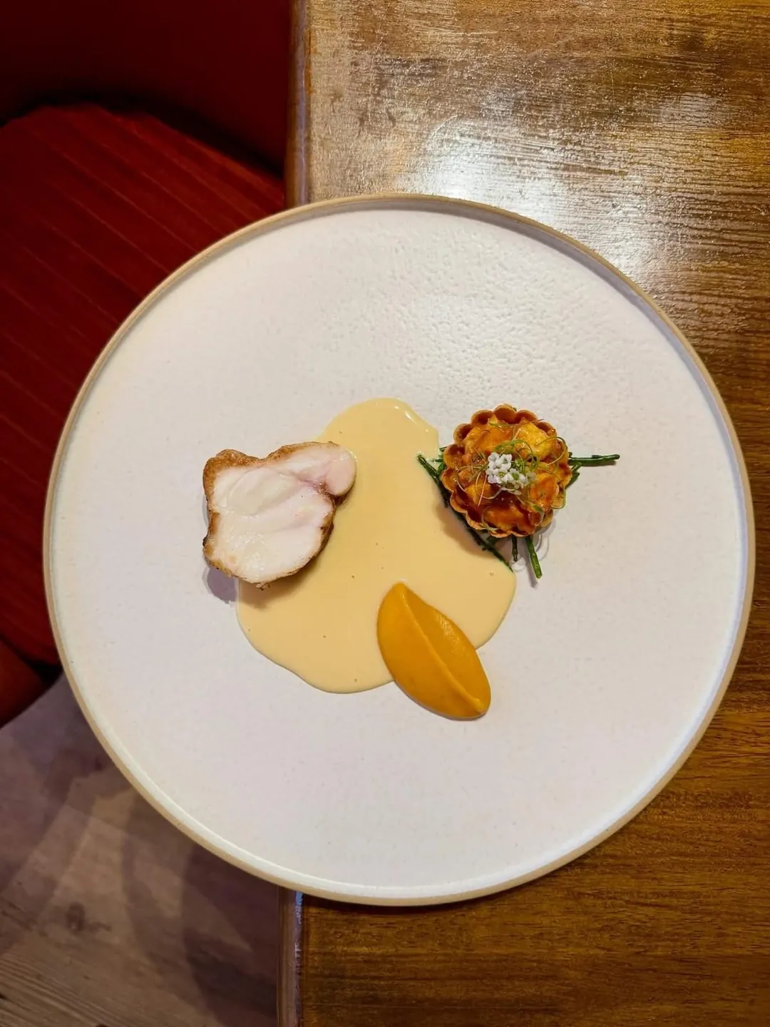 A minimal plate with a sauce, a purée and a single garnish